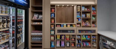 A commercial refrigeration unit with shelves stocked with beverages and snacks.