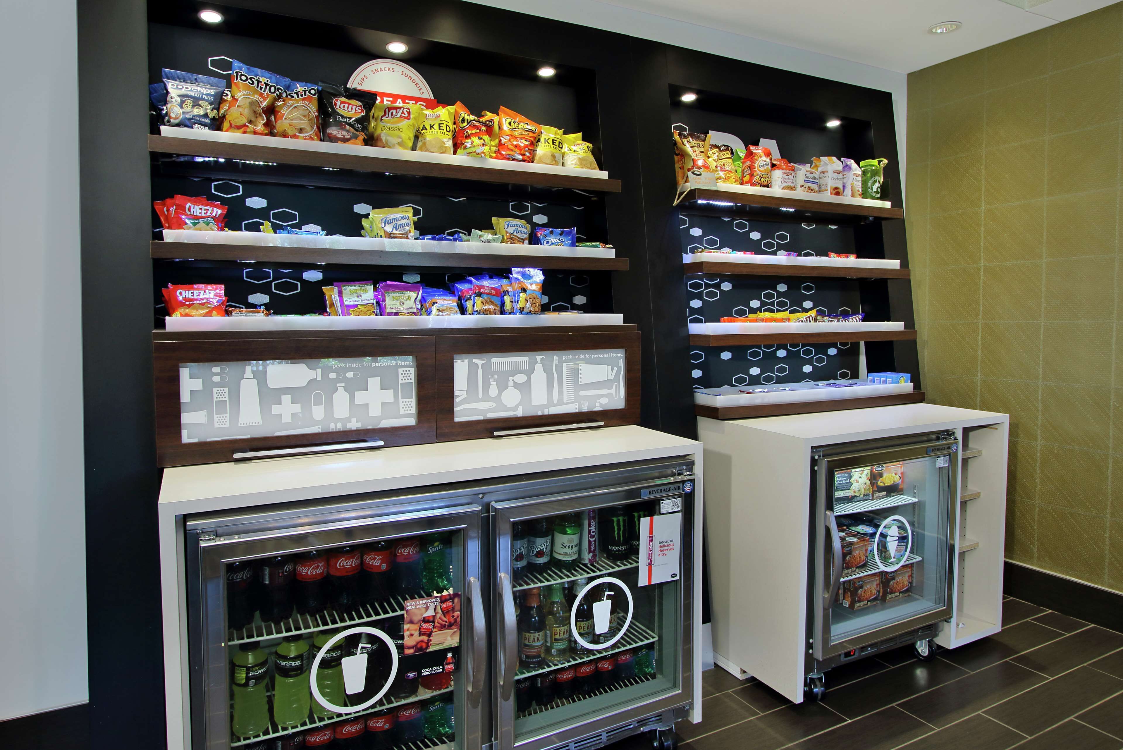 A snack display with various chips and snacks, and two refrigerated beverage dispensers with a variety of drinks.