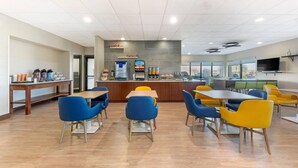 A modern cafe with a counter, seating area, and a television.