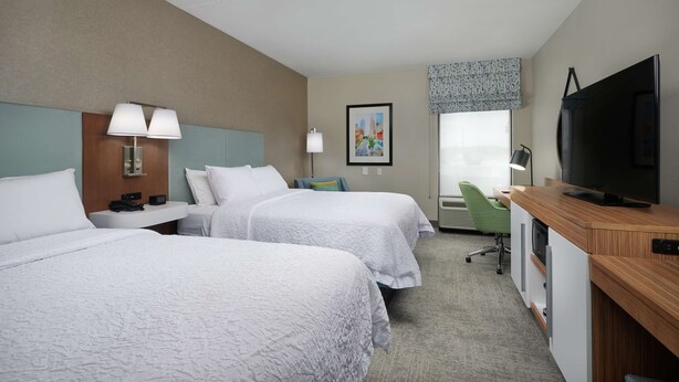 A hotel room with two beds, a desk, a television, and a window with a view. - Hampton Inn Louisville I-65 @ Brooks Rd. (Brooks)