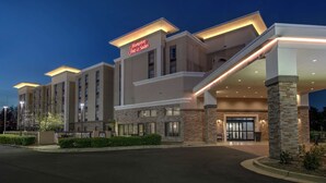 Edificio de Hampton Inn Suites con un diseño moderno, destacando una entrada principal y una fachada bien iluminada.