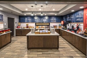 A modern breakfast bar with a sign reading "Happy Breakfast Starts Here," featuring a variety of food items and a coffee station.