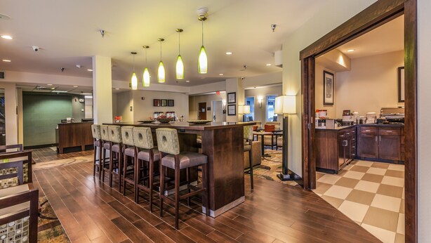 A spacious kitchen with a central island, bar stools, and pendant lighting. - Hampton Inn Colorado Springs-Airport (Colorado Springs)