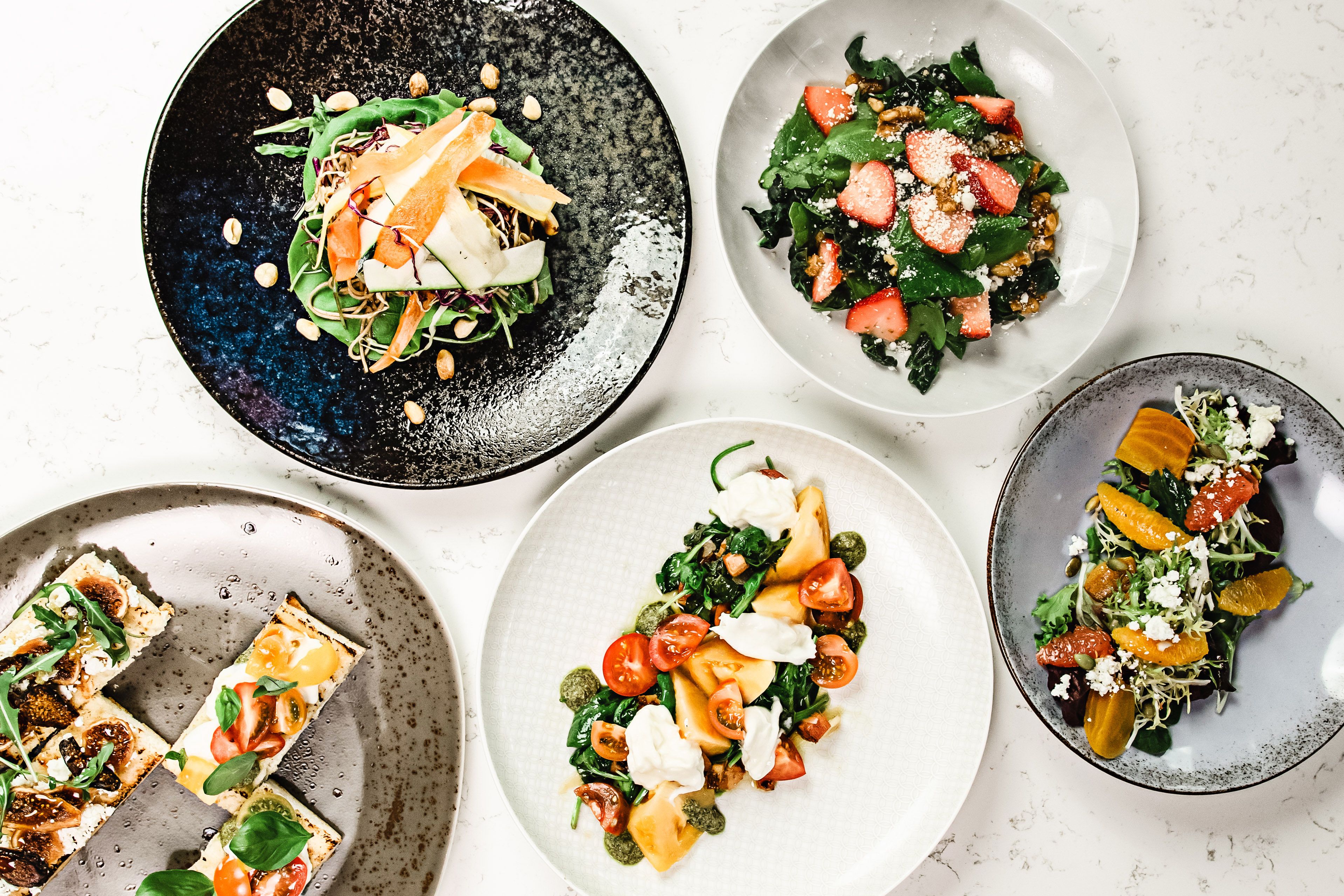 A variety of plated dishes with different ingredients and garnishes.