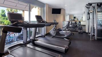 A gym with treadmills, elliptical machines, and weight equipment.