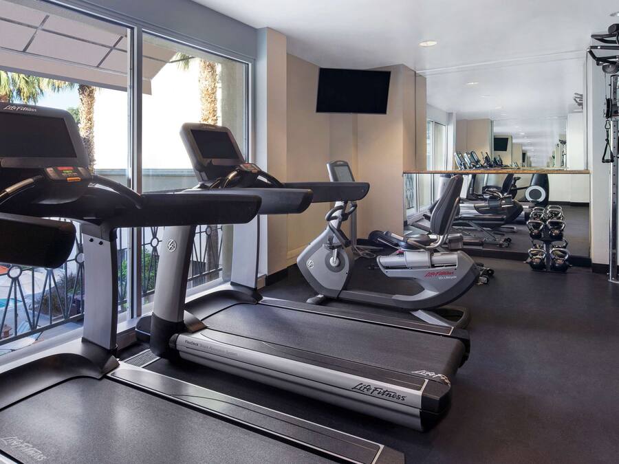 A gym with treadmills, elliptical machines, and weight equipment.