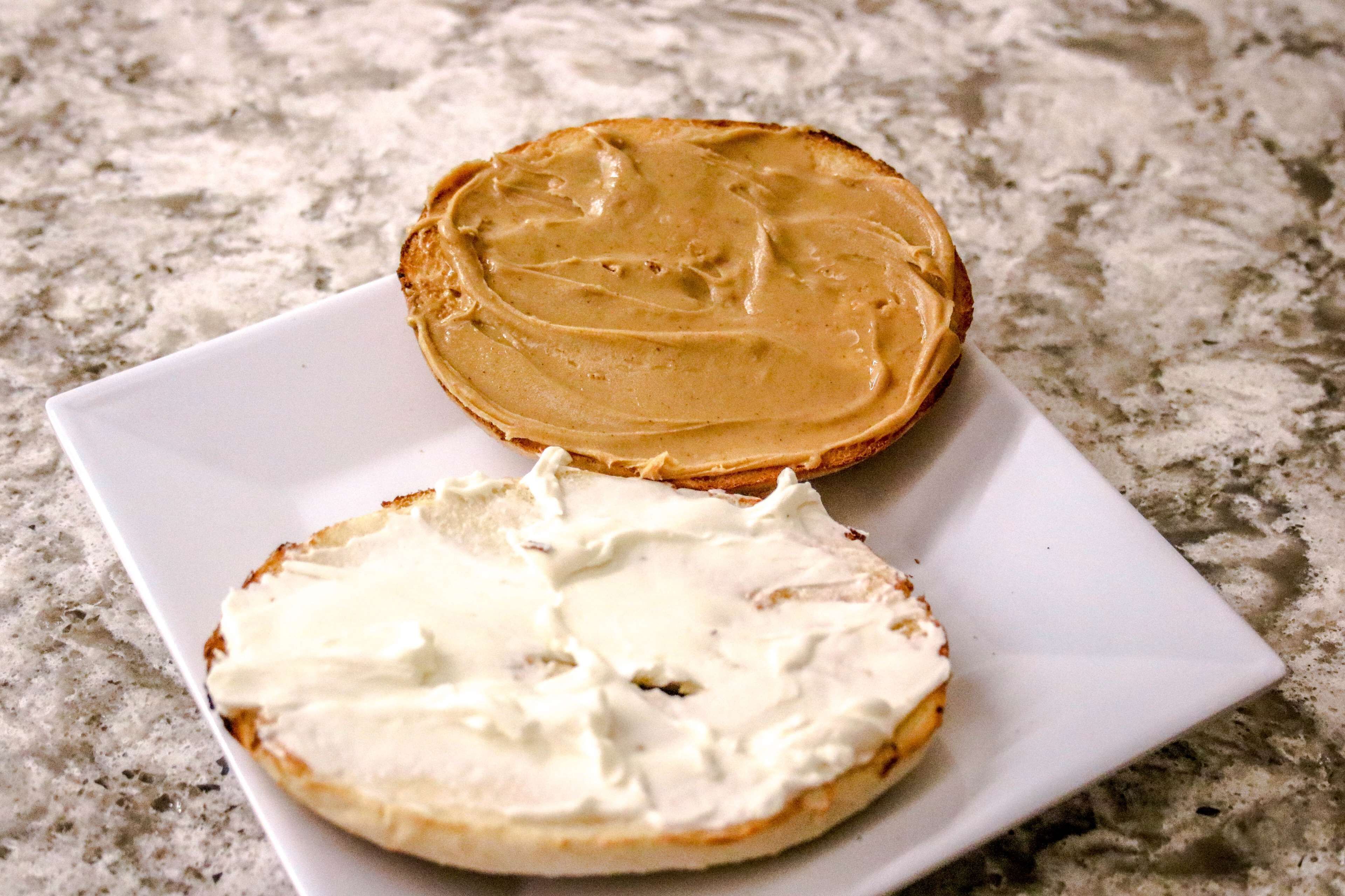 Dos bagels con distintos rellenos sobre un plato blanco.