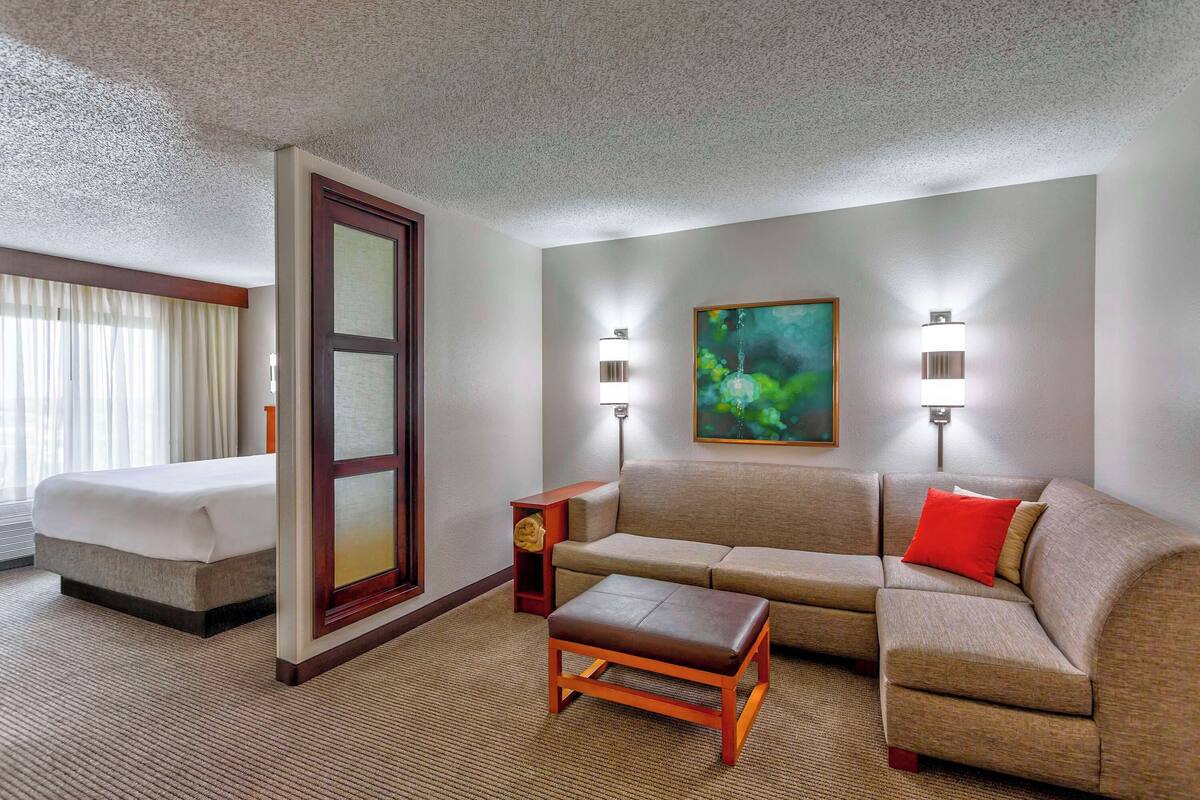Ein Hotelzimmer mit einem Bett, einem Sofa, einem Couchtisch und zwei Wandleuchten.