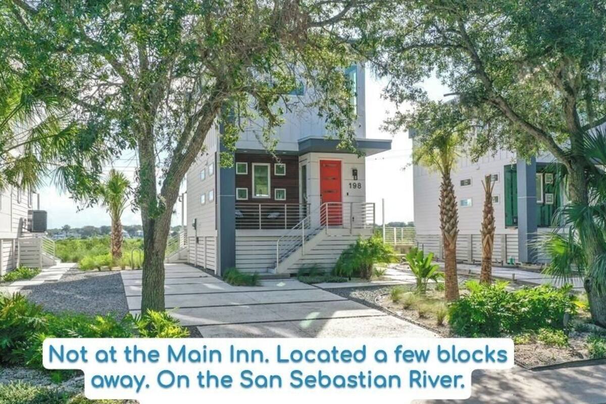 A modern hotel with a red door, located near the San Sebastian River.