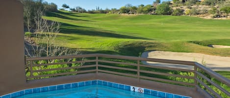 Piscina com vista para um campo de golfe.