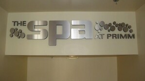 A sign for 'The Spa at Primm' with a modern design featuring metallic letters and circular shapes.