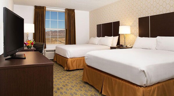 A hotel room with two beds, a desk with a TV, a chair, and a window with curtains. - Buffalo Bill's Resort & Casino, a Travelodge by Wyndham (Jean)