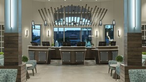 Ein Empfangsbereich mit modernem Design, der ein zentrales Pult mit zwei Laptops, stilisierte Stühle und ein großes Fenster mit Blick auf die äußere Bebauung beherbergt.