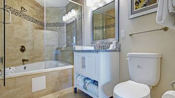 A modern bathroom with a glass-enclosed shower, a white sink with a blue countertop, and a white toilet.