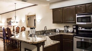 A modern kitchen with granite countertops, stainless steel appliances, and wooden cabinetry. - Hilton Vacation Club St. Augustine (St. Augustine)