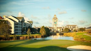 A golf course with a pond, surrounded by buildings with a prominent tower. - Hilton Vacation Club St. Augustine (St. Augustine)