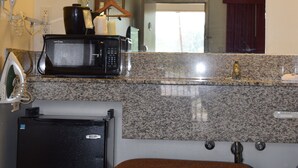 A compact kitchenette with a microwave, kettle, and small refrigerator. - Value Inn Livonia (Livonia)