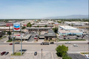 A Chevron gas station with a Discover Inn nearby, multiple parking lots, and a highway in the background. - Discovery Inn (Midvale)