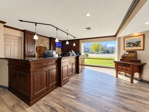 A modern kitchen with a wooden island, pendant lighting, and a view of the outside.