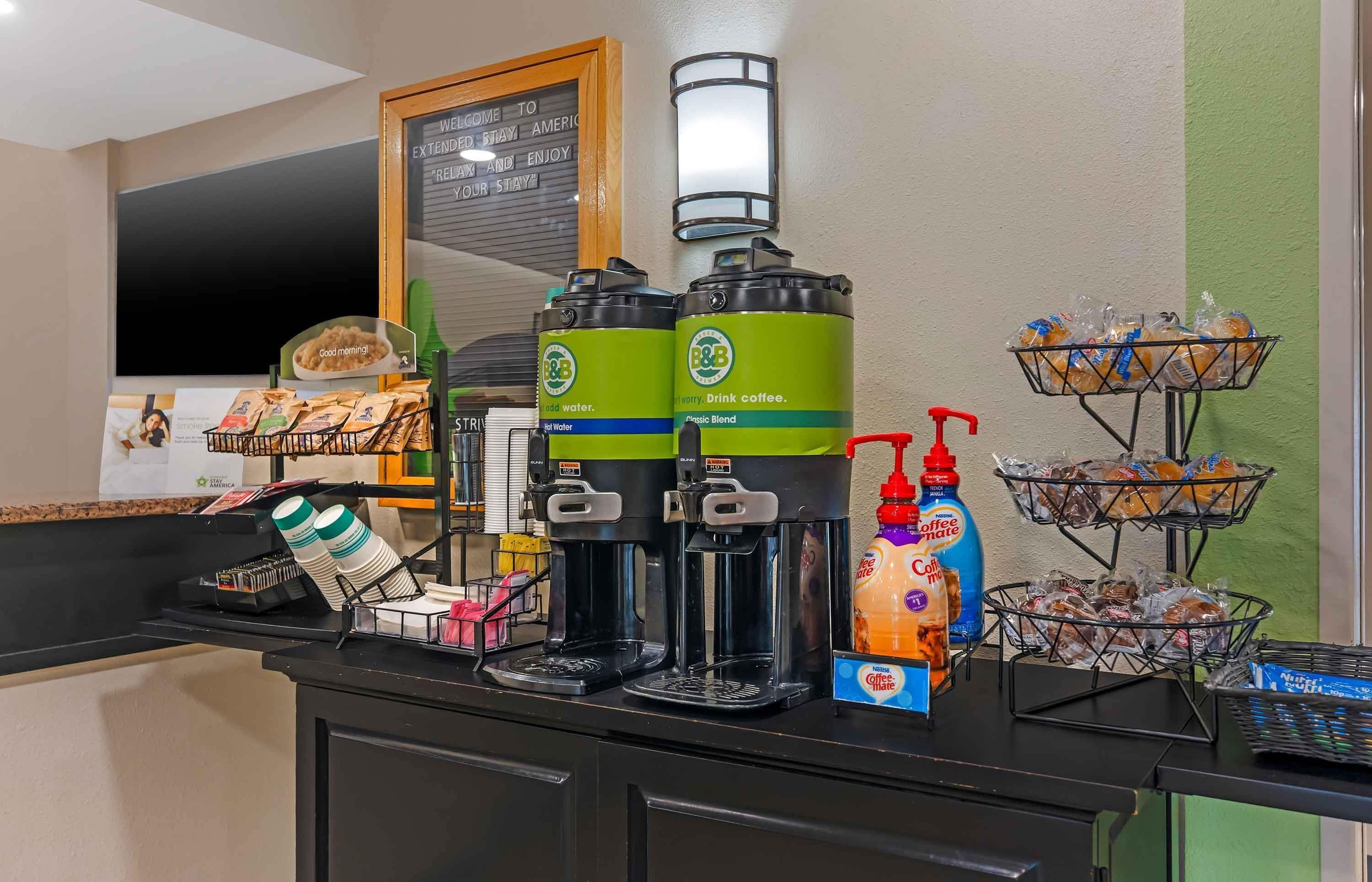 A coffee station with branded dispensers, a menu board, and a beverage dispenser.