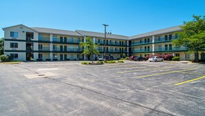 Un motel de varios pisos con estacionamiento al frente.