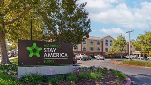 Señal de Extended Stay America Suites con un edificio al fondo.