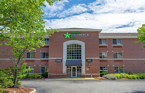 A StayAmerica Suites building with a brick facade, large windows, and a central entrance.