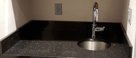 Una cucina con forno a microonde integrato, lavello e lavastoviglie.