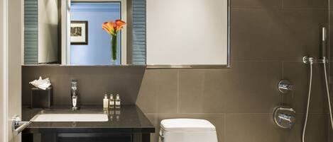 A modern bathroom with a sink, toilet, and shower.