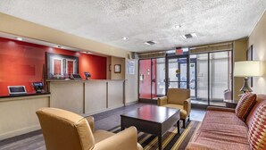A hotel lobby with a reception desk, seating area, and a large window with blinds. - Extended Stay America Suites San Antonio Colonnade Medical (San Antonio)