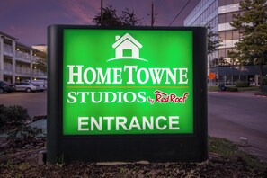 A sign for HomeTowne Studios by Red Roof, indicating the entrance to a building.