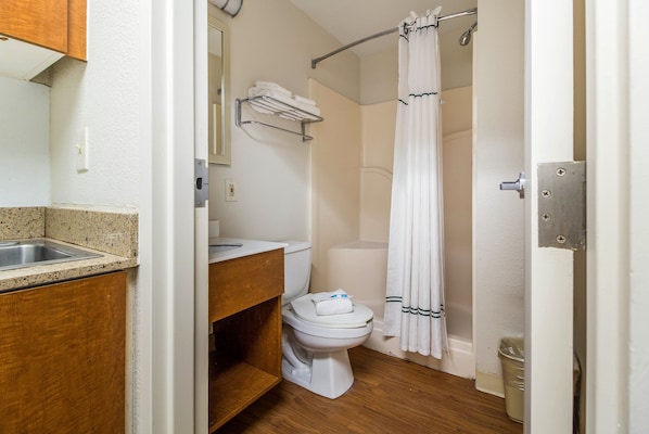 Un baño con lavamanos, inodoro y cortina de ducha.