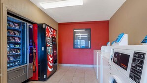 A laundry area with washing machines and a vending machine with snacks. - Extended Stay America Suites Houston The Woodlands (Spring)