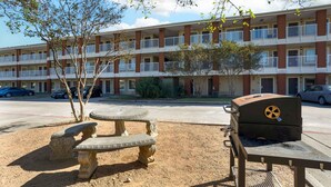 A multi-story apartment building with balconies, a barbecue grill, and outdoor seating. - Extended Stay America Suites Houston The Woodlands (Spring)