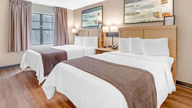 A hotel room with two beds, a large window with curtains, and abstract paintings on the wall. - Extended Stay America Suites Asheville Tunnel Rd (Asheville)