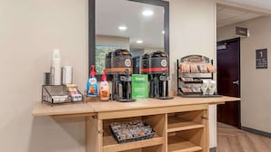 A coffee station with multiple coffee makers, a trash bin, and a sign indicating the location. - Extended Stay America Suites Asheville Tunnel Rd (Asheville)