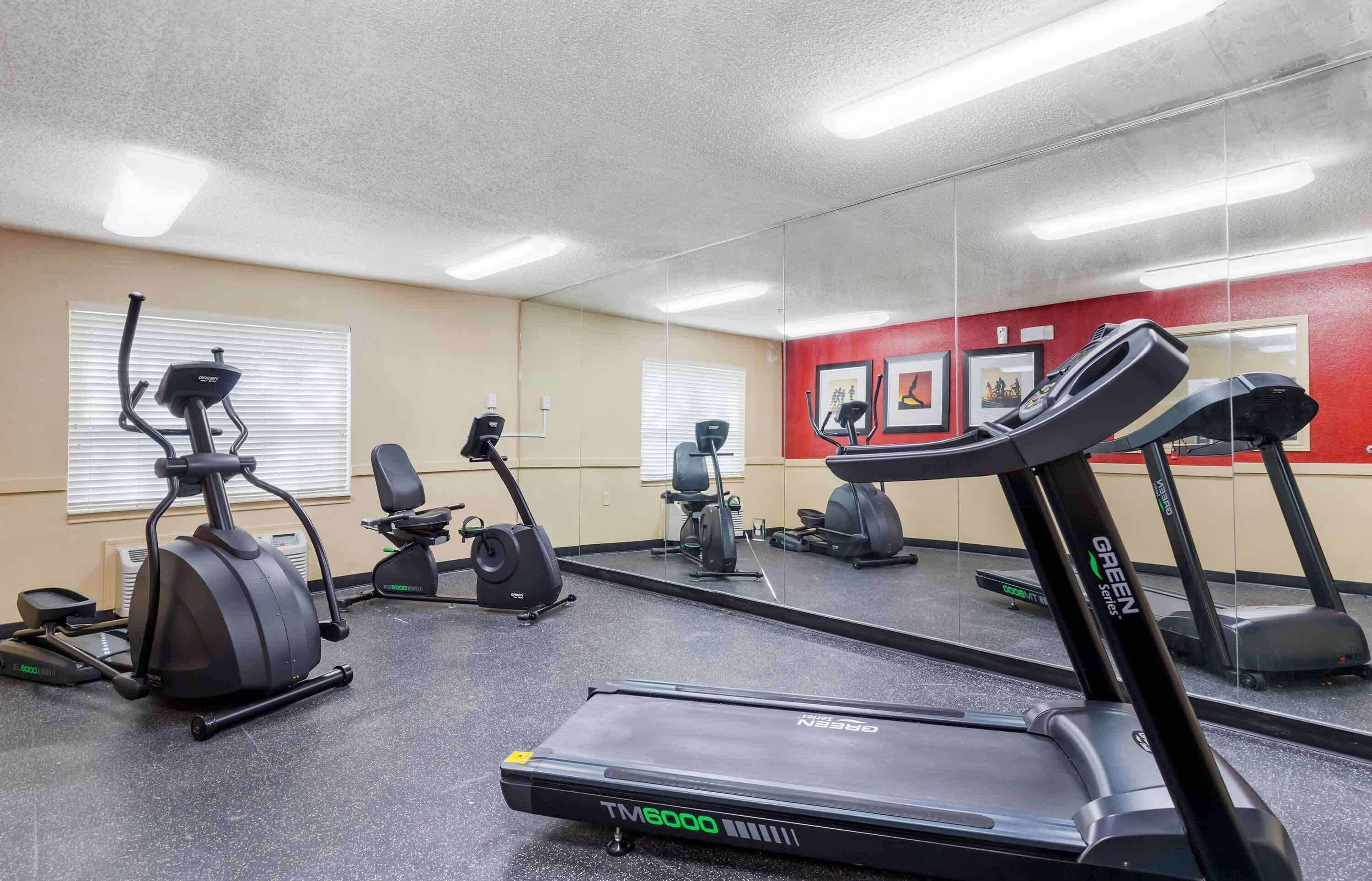 Une salle de sport équipée de tapis de course, de vélos d’appartement et d’appareils elliptiques.