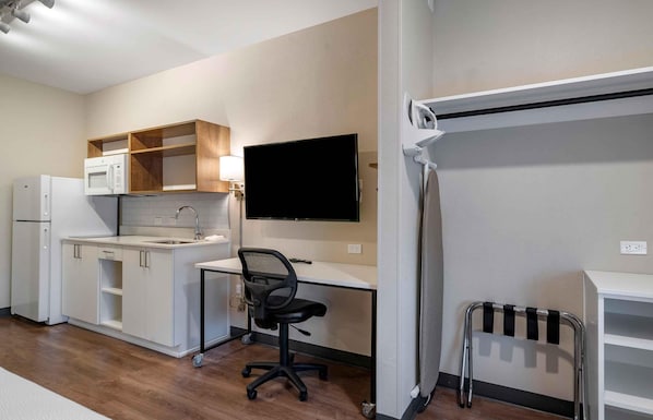 A compact kitchenette with a microwave, refrigerator, and sink.