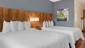 A hotel room with two beds, a wooden headboard, a bedside lamp, and a wall-mounted picture. - Extended Stay America Select Suites - Charlotte - University Place (Charlotte)
