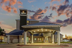 A hotel with a prominent sign, a covered entrance, and a parking area. - La Quinta Inn & Suites by Wyndham Panama City (Panama City)