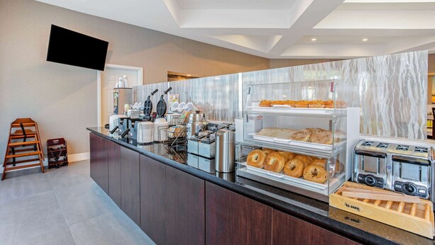 Eine Frühstückstheke mit Marmorrückwand, einem Flachbildfernseher und einem Toaster.