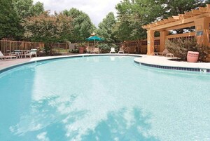 Una piscina al aire libre de temporada, sombrillas
