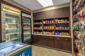 A self-service snack area with refrigerated display cases and shelves stocked with various snacks and beverages. - La Quinta Inn & Suites by Wyndham Pueblo (Pueblo)