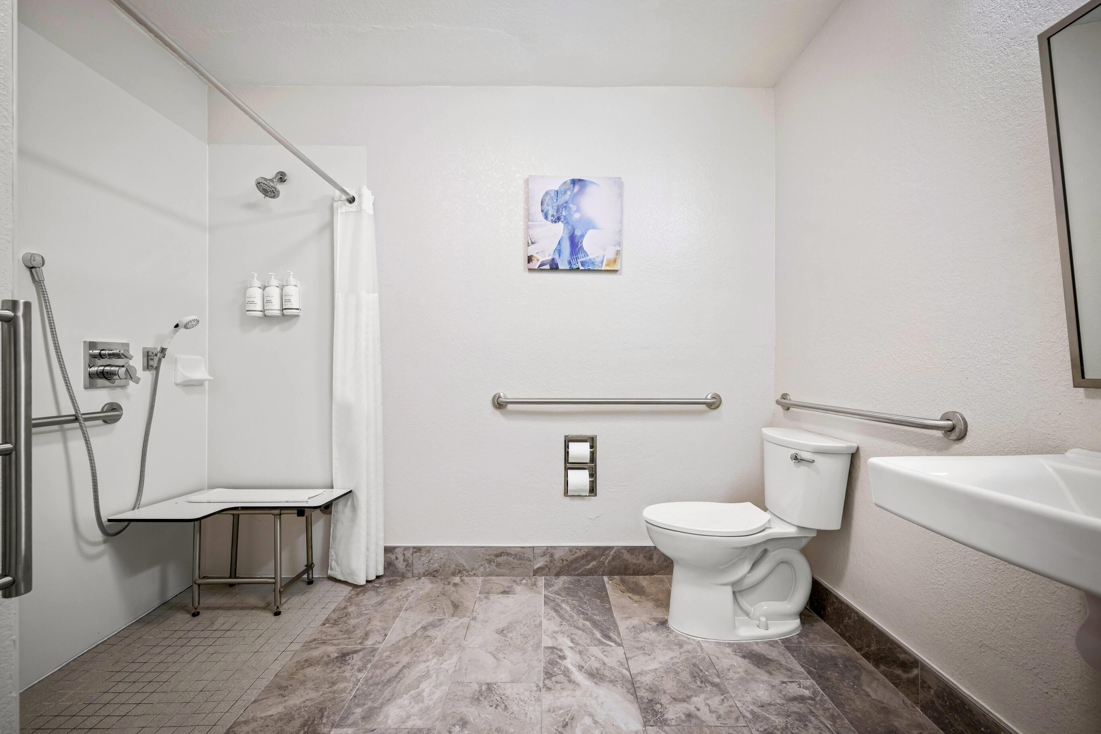 A bathroom with a shower, toilet, and sink.
