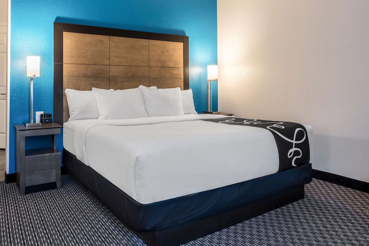 Ein Hotelzimmer mit einem großen Bett, zwei Nachttischen und einem Kopfteil.