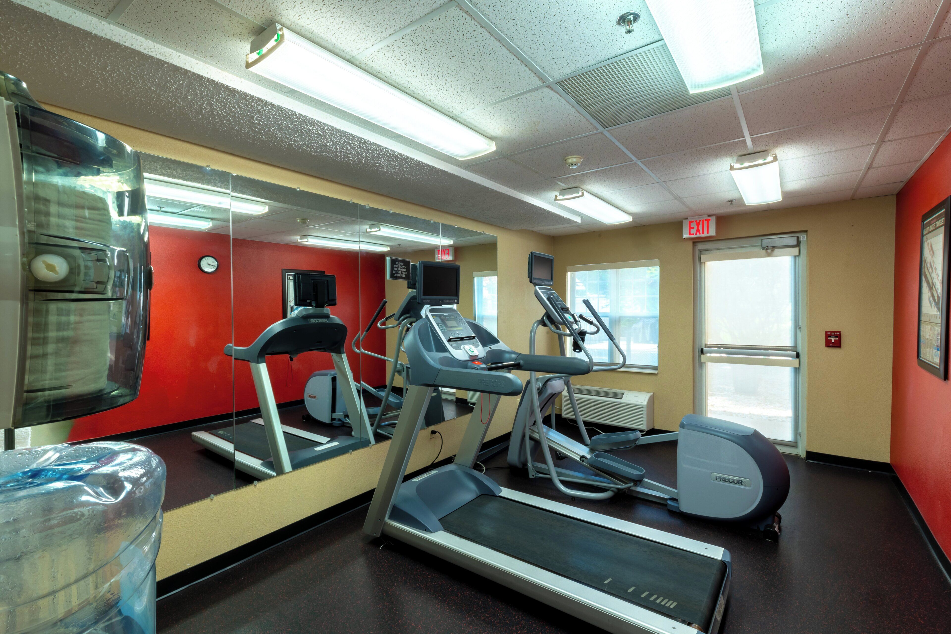 A gym with treadmills, a stationary bike, and a mirrored wall.