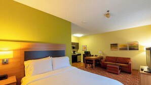 Una habitación de hotel con una cama, un escritorio, un sofá y una televisión.