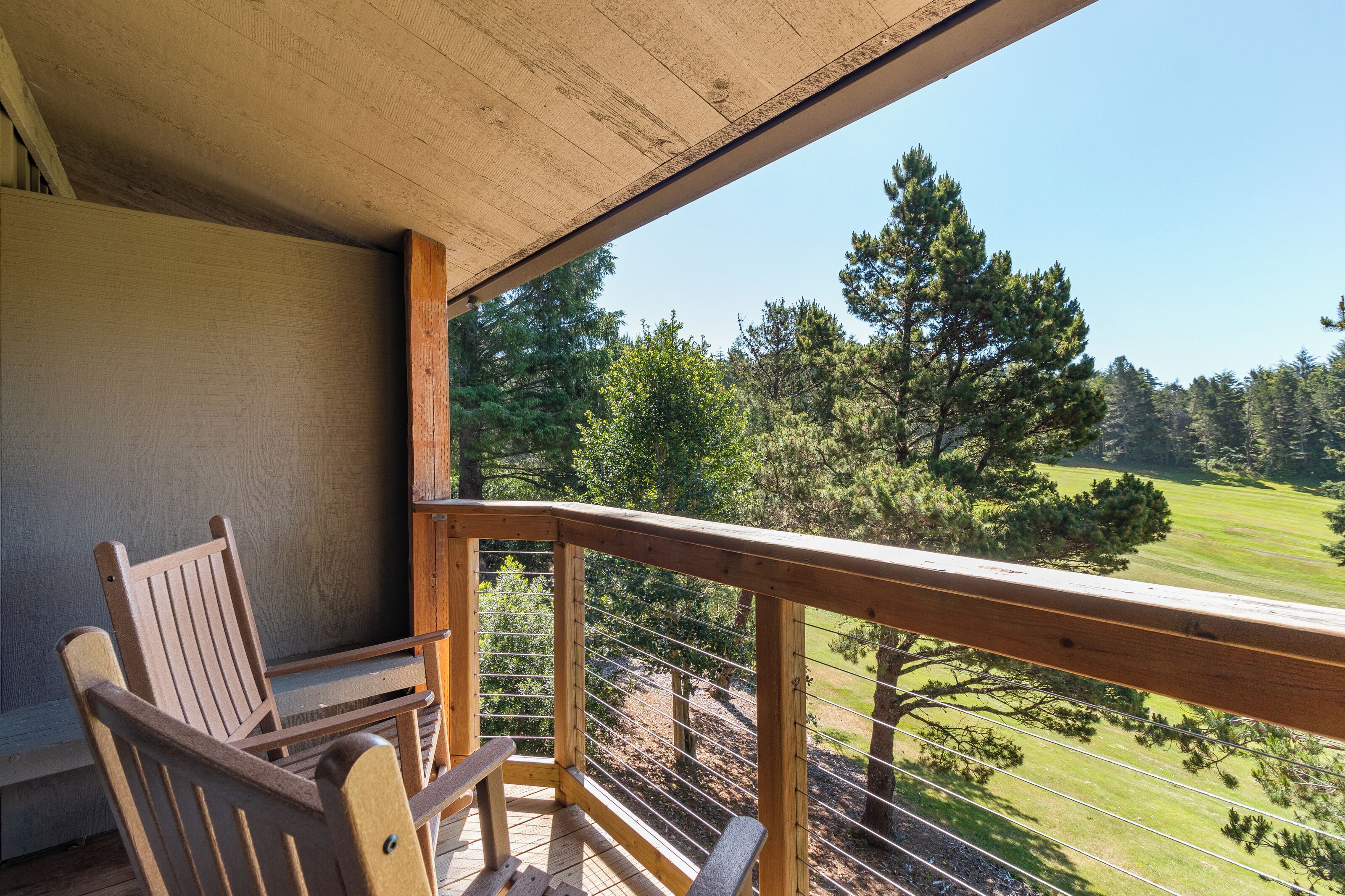 A wooden deck with a view of a golf course.