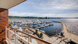 A marina with numerous boats docked, a wooden pier, and a view of the water and distant trees. - The Woodmark Hotel & Still Spa on Lake Washington (Kirkland)