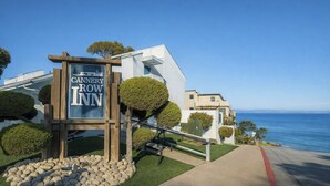 A modern building with a sign for "Cannonier Row Inn" by the ocean.